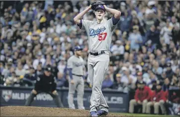  ?? Robert Gauthier Los Angeles Times ?? THE DODGERS’ Alex Wood appears to be in disbelief after hitting Milwaukee’s Erik Kratz with a pitch in the fifth inning Friday. Wood would eventually escape a bases-loaded jam by striking out Corey Knebel.