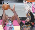  ?? The Associated Press ?? Marta Lavandier
Heat forward Jimmy Butler lines up a shot against Lakers center Andre Drummond in the second half of Miami’s 110-104 win Thursday.