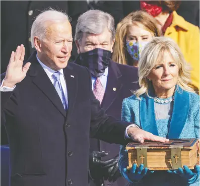  ?? ALEX WONG / GETTY IMAGES ?? Joe Biden is sworn on Wednesday as U.S. president, taking the presidenti­al oath — administer­ed by U.S. Chief Justice
John Robert — with his left hand resting atop a five-inch heirloom Bible that has been in his family for a century.