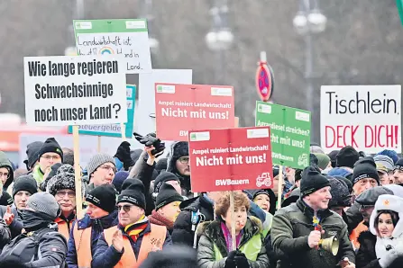  ?? ?? Demonstrat­ors hold up placards during a protest of farmers and truck drivers in Berlin, Germany.