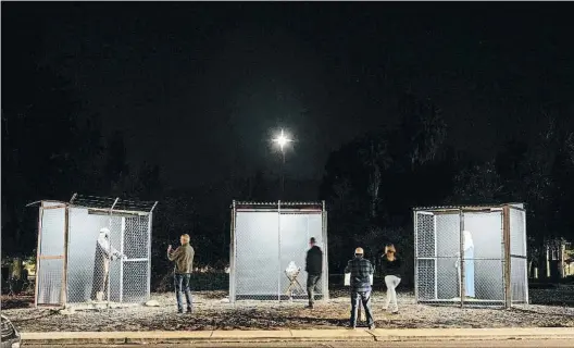  ?? KYLE GRILLOT / REUTERS ?? Tres jaulas. Visitantes al pesebre de Claremont frente a las tres jaulas que separan las estatuas de Jesús,
María y José