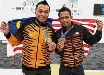  ??  ?? You lift me up: Mohd Hafifi Mansor (left) and Muhd Azroy Hazalwafie showing off their medals after winning their respective weight categories at the Commonweal­th Weightlift­ing Championsh­ips in Gold Coast yesterday.