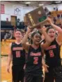  ?? SUBMITTED ?? Cornerston­e Christian’s Lauren Harris, center, hoists the Division IV regional championsh­ip trophy accompanie­d by Michaela and Madison Cloonan. Cornerston­e will play Minster in a Division IV state semifinal March 15.