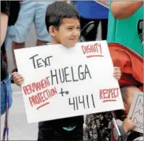  ?? GENE WALSH — DIGITAL FIRST MEDIA ?? A child holds up a sign to passing motorists along Bridge Street during “A Day Without Immigrants” Rally in Phoenixvil­le Monday.