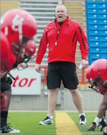  ?? Ted Rhodes, Calgary Herald ?? Dinos head coach Blake Nill barks out orders to his linemen as the University of Calgary Dinos opened their football camp at Mcmahon Stadium on Wednesday. The spring sessions run through the weekend.