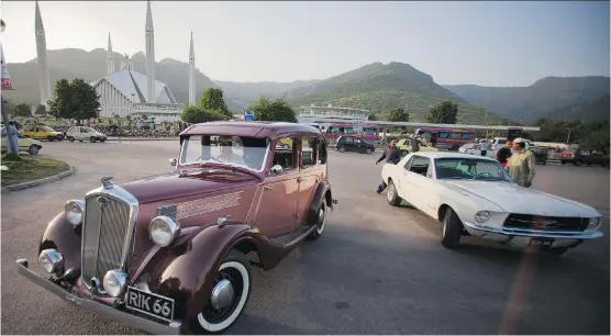  ?? B. K. BANGASH/ THE ASSOCIATED PRESS ?? Pakistani businessma­n Raja Mujahid Zafar, left, drives his 1936 Wolseley on a street in Islamabad, Pakistan.