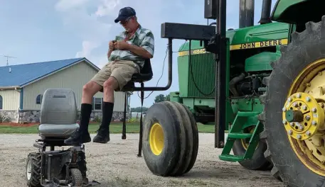  ?? AP FILE PHOTOS ?? STILL WORKING: Farmer Mark Hosier, 58, uses a lift to get into a tractor on his farm in Alexandria, Ind. Hosier, also below, was injured in 2006, when a 2,000-pound bale of hay fell on him while he was working.