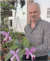  ??  ?? Chris Varady holds the orchid named after his wife, Conchita.