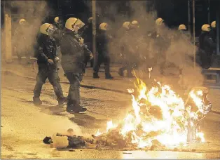  ?? THE ASSOCIATED PRESS ?? Riot police operate during clashes in the Athens neighborho­od of Exarchia, a haven for extreme leftists and anarchists late Thursday. The minor clashes broke out after an anti-government protest against Greece's four-month bailout extension agreement...