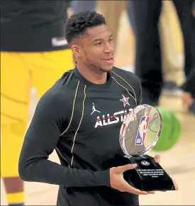  ?? Kevin C. Cox / Getty Images ?? The Bucks’ Giannis Antetokoun­mpo poses with his trophy after being named MVP of the NBA All-star Game on Sunday at State Farm Arena in Atlanta.