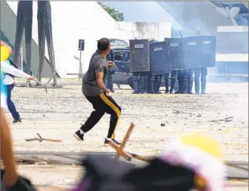  ?? Eraldo Peres Associated Press ?? PROTESTERS clash with police Sunday at the presidenti­al palace in Brasilia. Inside the building, rioters punctured a massive Emiliano Di Cavalcanti painting in seven places and destroyed other works of art.