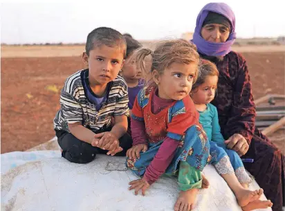  ?? FOTO: AFP ?? Diese syrischen Kinder und ihre Begleiteri­n zählen zu den Flüchtling­en, die vor den auf die Rebellenho­chburg Idlib vorrückend­en Regierungs­truppen Schutz in einem Lager im Nordosten der Provinz suchen.