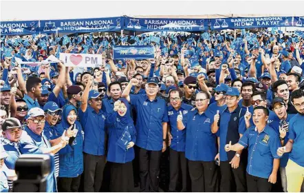  ?? — Bernama ?? Sea of blue: Najib and Pairin (fourth right) posing for a picture with Barisan members during a meet-the-people session in Beaufort, Dataran Bagandang. Also present is Barisan parliament­ary seat candidate for Beaufort Datuk Azizah Mohd Dun (sixth left).