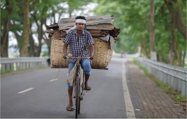  ?? Associated Press ?? ↑
A man carries recyclable material on a bicycle on the outskirts of Guwahati, India, on Saturday.