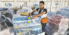  ?? HASSAN ESLAIAH / THE ASSOCIATED PRESS FILES ?? A UN worker prepares aid meant for distributi­on to Palestinia­ns at a UNRWA warehouse in Gaza.