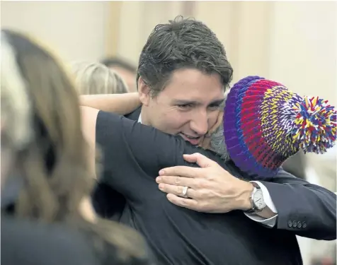  ?? ADRIAN WYLD/THE CANADIAN PRES ?? An aboriginal woman hugs Prime Minister Justin Trudeau before a meeting with national aboriginal organizati­ons on Parliament Hill in 2015. Trudeau has promised to act on all 94 Truth and Reconcilia­tion Commission recommenda­tions, one of which is to...