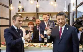  ?? — aFP ?? Here’s to you: Xi and macron tasting wine as they visit France’s pavilion during the China Internatio­nal Import expo in shanghai.