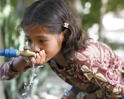  ?? Courtesy of Good People ?? An unnamed girl drinks tap water using her hand in this undated photo. Yoido Full Gospel Church has provided help for those in need abroad through its internatio­nal relief organizati­on, Good People, since 1999.