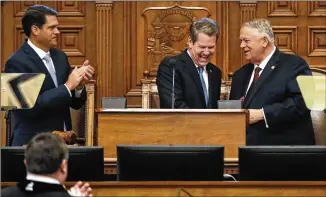  ?? BOB ANDRES / BANDRES@AJC.COM ?? Gov. Brian Kemp, flanked by Lt. Gov. Geoff Duncan (left) and House Speaker David Ralston, receives applause after he delivered his first State of the State address on Thursday. Kemp released his first budget, which includes a $3,000 pay raise for teachers.