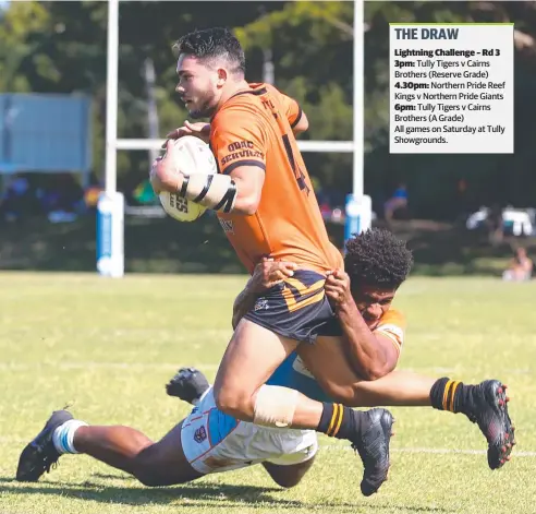  ?? Picture: BRENDAN RADKE ?? STOP SIGN: Tully's Michael Carroll is wrapped up by the Reef Kings’ Sami Raivaroro in the Round 2 match of the Lightning Challenge between the Northern Pride and the Tigers at Stan Williams Park.