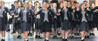  ??  ?? Respect . . . Te Wairua Puhou, the combined kapa haka group of Otago Girls’ High School and Otago Boys’ High School, greets the White Ferns and their English counterpar­ts on their arrival at Dunedin Airport yesterday. Right: The White Ferns perform a waiata in response.