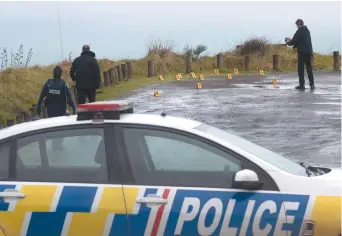  ??  ?? La police collecte et photograph­ie des preuves sur le stationnem­ent du belvédère de la gorge Te Toto sur Whaanga, au sud de Raglan, en Nouvelle-Zélande. - La Presse canadienne: Alan Gibson/New Zealand Herald