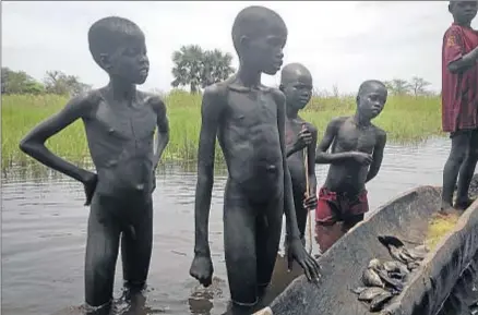  ?? JOSPHAT KASIRE / AP PHOTO ?? Unos niños acaban de pescar en un río del estado de Unidad, en Sudán del Sur, en un área devastada por la guerra