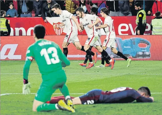  ?? FOTO: EFE ?? Arbilla, desolado en el suelo del Sánchez Pizjuán, y Riesgo con los jugadores del Sevilla al fondo celebrando el segundo gol de Sarabia