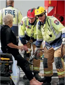  ?? PHOTOS: MATT SHAND/STUFF ?? Emergency services staff attend to the woman after she was rescued from the hole.