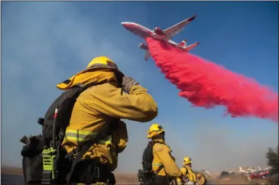  ?? The Associated Press ?? INCOMING: Firefighte­rs brace themselves for incoming fire retardant during the Easy Fire Wednesday in Simi Valley, Calif. Fire officials say they’re investigat­ing the cause of the fire.