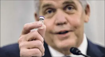  ?? Samuel Corum / Getty Images ?? Wesley Wheeler, president of Global Healthcare at UPS, holds up a sample of the vial to be used to transport the Pfizer COVID-19 vaccine during testimony Thursday in Washington.