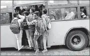 ?? AP/AIJAZ RAHI ?? Students hang three deep onto the door of a crowded, moving bus on Wednesday in Bangalore, India, as the world’s second-most populous nation marked World Population Day.