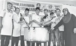  ??  ?? SIMBOLIK: Dr Abdul Rahman bersama tetamu jemputan lain menggaul bubur sebagai simbolik perasmian Program Jerayawara Bubur Lambuk SABERKAS-BERNAS 2017 Zon Santubong, di Kuching semalam.