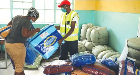  ??  ?? Red Cross Society of Zimbabwe employee, Mr Jayson Mhene (right) hands over blankets to Mrs Ruvimbo Mazive who was evacuated from Garikai Camp in Chimaniman­i to Mutambara Mission last week as part of precaution measures taken by Government ahead of the fall of Tropical Depression Chalane.— Picture by Tinai Nyadzayo