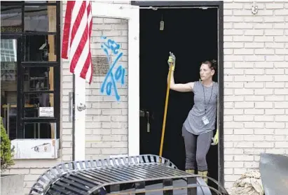  ?? JEN RYNDA/BALTIMORE SUN MEDIA GROUP ?? Su Casa’s Tracee Meadd takes a break Tuesday from cleaning the store on Main Street in Ellicott City after Sunday’s flood.