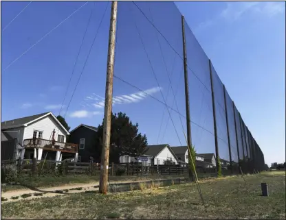  ?? ANDY CROSS — THE DENVER POST ?? Tall fencing protects houses along the driving range of the defunct Park Hill Golf Club on July 31, 2019.