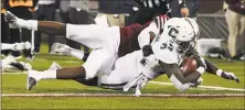  ?? Jessica Hill / Associated Press ?? UConn running back Kevin Mensah scores a touchdown as he is tackled by UMass linebacker Jarvis Miller on Saturday.