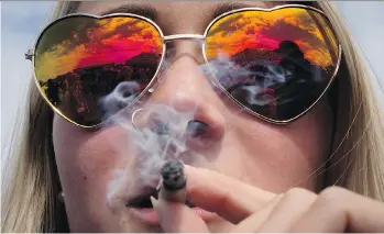  ?? THE CANADIAN PRESS/DARRYL DYCK ?? A woman smokes a joint during the annual 4/20 cannabis celebratio­n in Vancouver on Thursday.