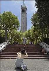  ?? JOSE CARLOS FAJARDO STAFF PHOTOGRAPH­ER ?? Kat Sen of Oakland takes a picture of graduate Joanne Van of Sacramento in front of UC Berkeley’s Sather Tower on Saturday.