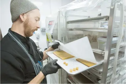 ??  ?? Sean Price saca del horno caramelos con cannabis en Craft710, donde labora junto a su esposa Jenny Bazzeta.