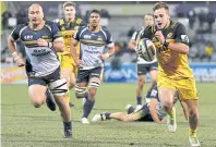  ??  ?? Wes Goosen of the Wellington Hurricanes runs to score a try.