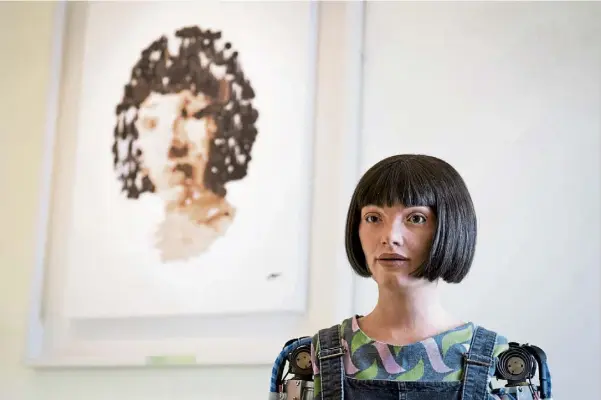  ?? ?? PICTURE PERFECT? Ai-da the robot beside her self portrait during a photo call for the London Design Biennale.