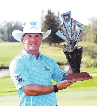  ?? VAUGHN RIDLEY/GETTY IMAGES ?? American golfer Scott McCarron holds up the championsh­ip trophy after successful­ly defending his Shaw Charity Classic title on Sunday at the Canyon Meadows Golf and Country Club.