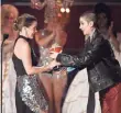  ?? KEVORK DJANSEZIAN, GETTY IMAGES ?? Beauty and the Beast’s Emma Watson was handed the golden popcorn for best actor by nonbinary actor Asia Kate Dillon.