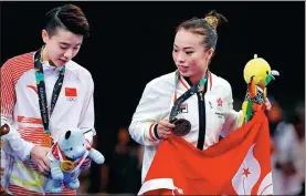  ?? REUTERS ?? Gold medalist Tang Lu of Chinese mainland and bronze medalist Yuen Ka-ying of Hong Kong SAR celebrate during the medal ceremony at the Asian Games in Jakarta on Monday.