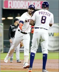  ?? MICHAEL WYKE — THE ASSOCIATED PRESS ?? Houston’s Yuli Gurriel, left, rounds third base and reaches to shake hands with third base coach Gary Pettis (8) after Gurriel’s home run during the first inning Wednesday in Houston.