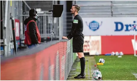  ??  ?? Prüfender Blick: Schiedsric­hter Arne Aarnink schaut sich die Szene vor dem Elfmeter für Heidenheim noch einmal an.