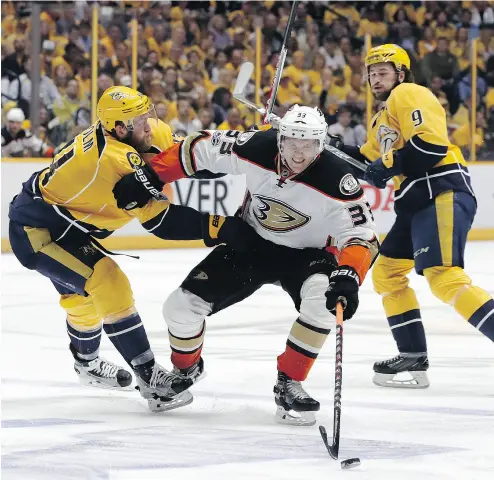  ?? MARK HUMPHREY / THE ASSOCIATED PRESS ?? Anaheim’s Jakob Silfverber­g battles for the puck between Nashville’s Filip Forsberg and Mattias Ekholm in Thursday’s Game 4 of their Western Conference final. The game went into overtime — for a report go to nationalpo­st.com/sports.