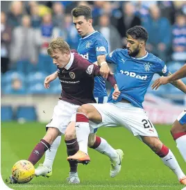  ??  ?? Rangers’ Daniel Candeias tackles Hearts teenager Lewis Moore