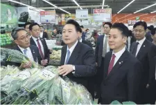  ?? ?? El presidente Yoon Suk Yeol (C) en un mercado de Seúl. (AFP)